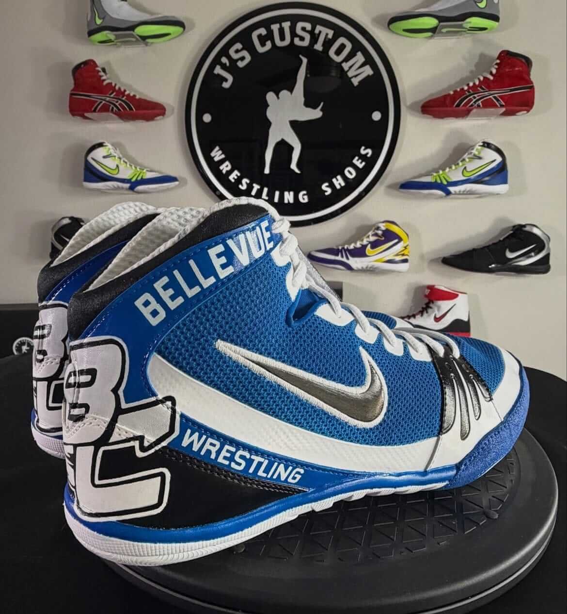 Custom hand-painted wrestling shoes with team name design in blue and white